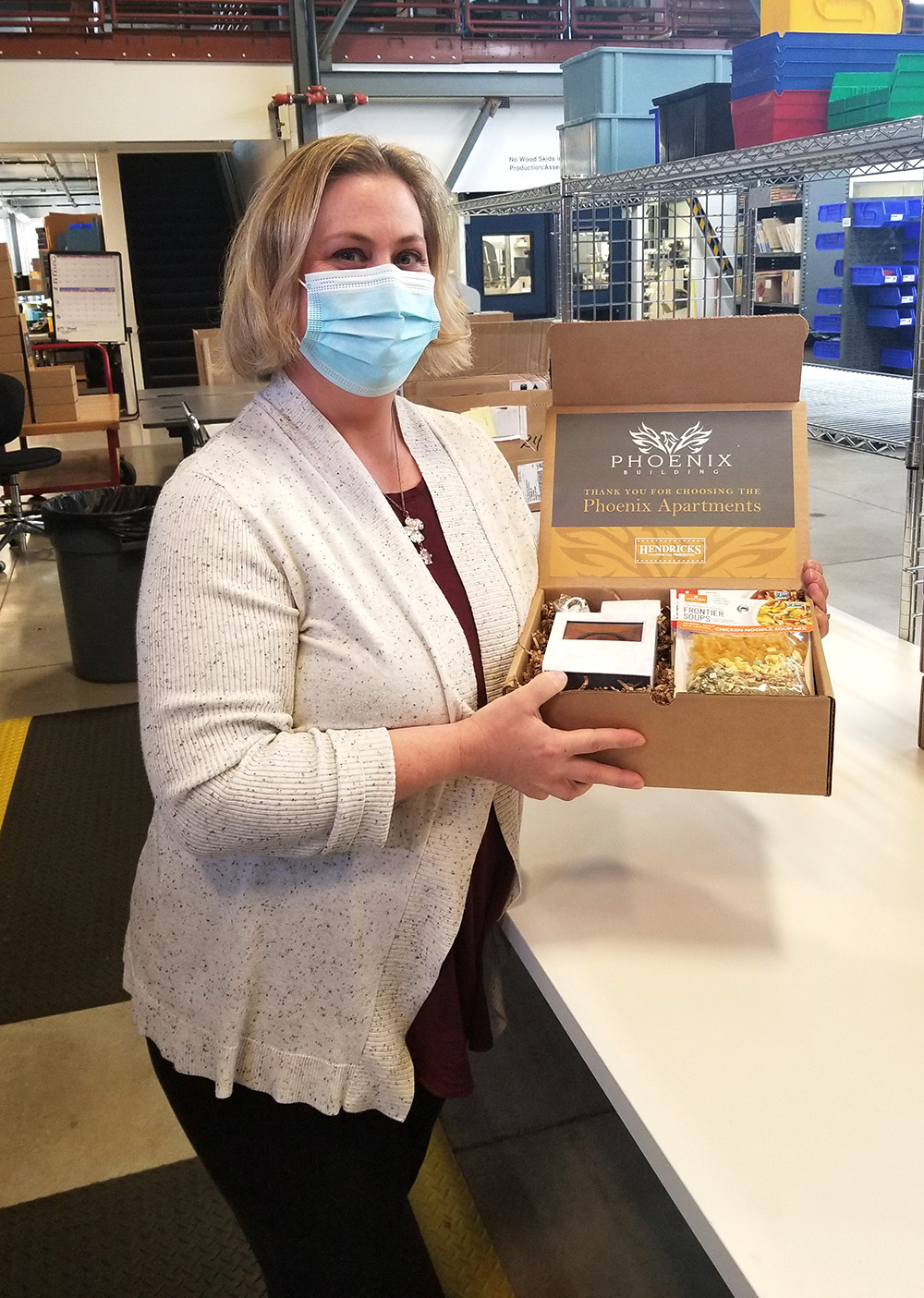 Colleen holds curated gift box for Phoenix Apartments